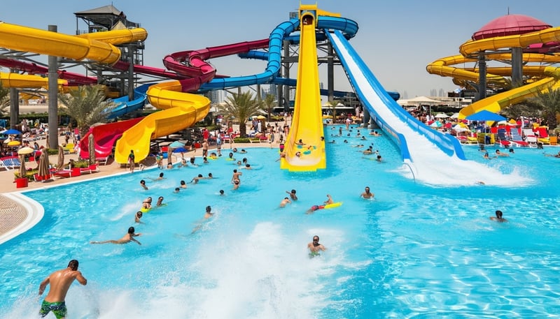 A vibrant Dubai water park with pools, slides, and guests enjoying the sun.